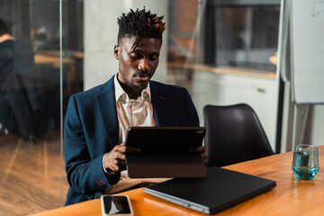 Portrait of successful businessman in office. Handsome businessman using digital tablet