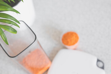 Excellent blurred light kitchen background with a container for bulk, a measuring cup and a kitchen scale, copy space.