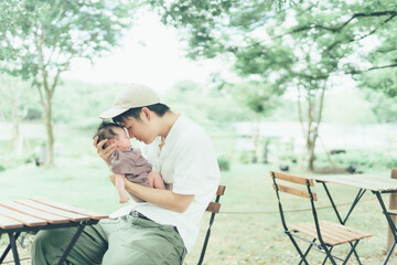 ベンチに座るお父さんと赤ちゃん