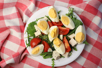 healthy hearty diet salad of products with a low glycemic index of arugula greens and spinach eggs and tomatoes with cheese pieces