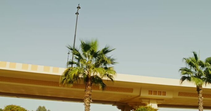 Road junction, bridge with oriental patterns among palm trees on a clear sunny day
