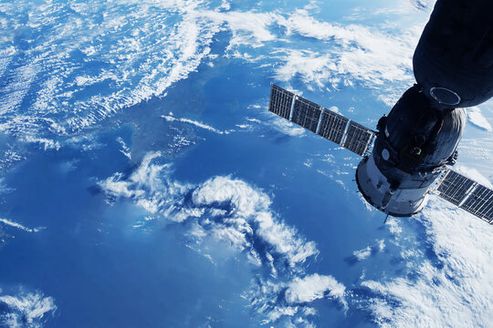 A space satellite above the Earth's surface. Elements of this image furnished NASA.