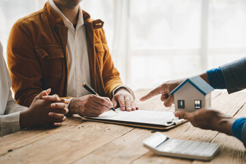 Real estate agents deliver replica homes to couples. Mortgage agreements, loans, leases and home sales. and home insurance contract