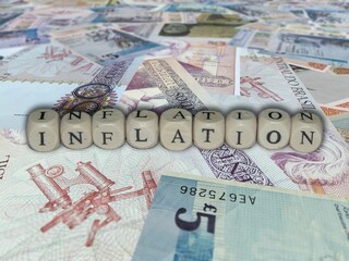Pile of various currencies in a jumbled stack with words displayed at the top. Inflation concept.