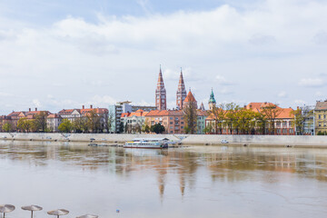 Szeged, Hungary colorful cityscape is reflected in the river Tisza below, framed by clouds and...