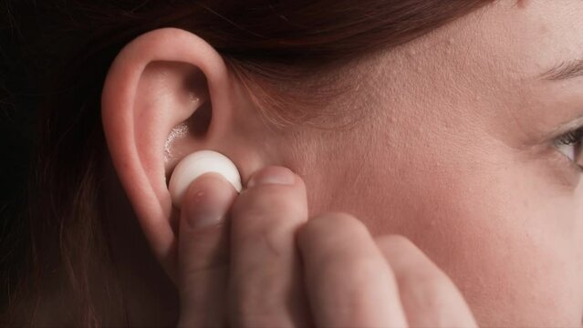 wireless technologies, young woman uses modern headphones to listen to music or phone conversations, close up