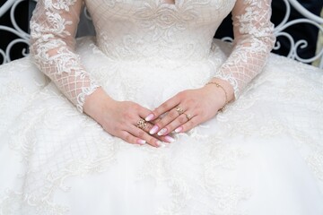 Pretty bride in white dress with decorated nails