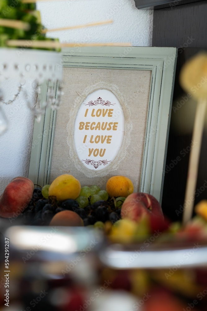 Poster Text on decorated book cover I LOVE BECAUSE I LOVE YOU with fruits on wedding table