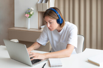 Young attractive woman in headphones learning online at home. Distance education concept	