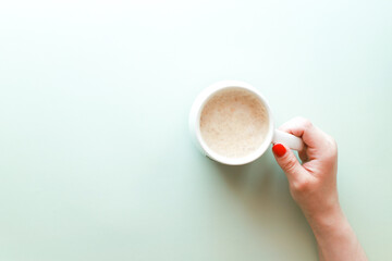 Flat lay hand holding coffee cup