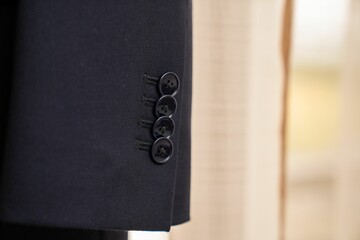Closeup of buttons on a black suit sleeve