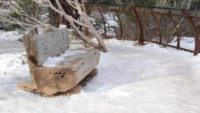 Wood bench on the edge of the Grand Canyon National Park with snow, USA
