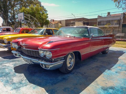 Old red luxury 1960 Cadillac coupe DeVille in a park.  AAA 2022 classic car show.