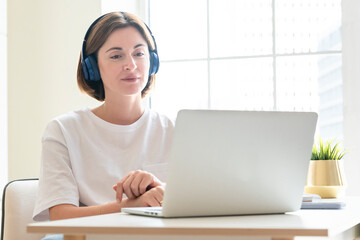 Naklejka premium Young attractive woman in headphones learning online at home. Distance education concept 