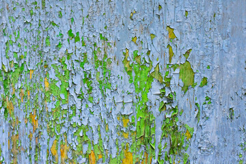 Abstract background of cracked weathered old wood with layers of paint