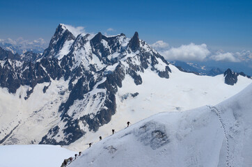 group of mountaineers climbing up on snow slopes, Mont Blanc massive, French Alps  - 594296069