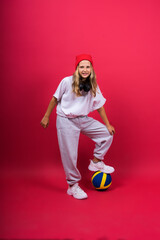 Portrait of a cute eight year old girl in volleyball outfit isolated on red yellow background