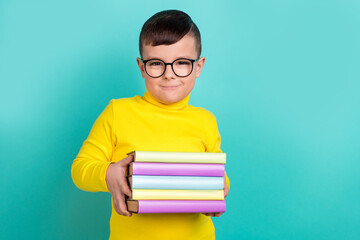 Photo of clever boy student holding pile textbook enjoy learning classroom isolated on aquamarine color background