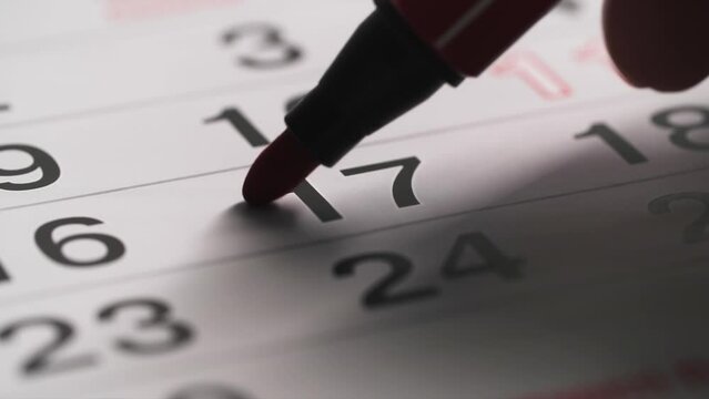 planning a month, red felt-tip pen marks the date on the calendar, close-up