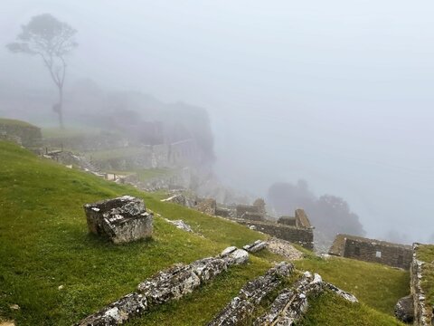 Landscape of Sayacmarca covered in the fog on a rainy day in Peru