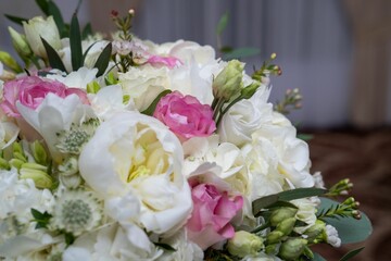 Closeup of a vibrant and lush bouquet of white and pink flowers and greenery.
