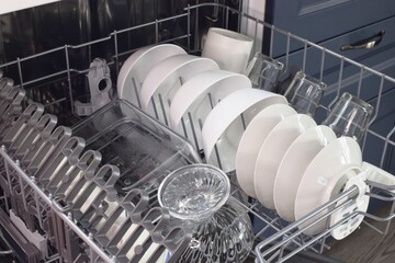 White dishes and glasses in the dishwasher. 