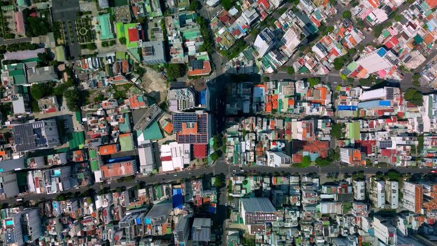 Top view of down birds eye city Nha Trang street with skyscrapers of Vietnam, urban buildings street in Vietnam with busy car traffic. Vietnam city view from above. 4K