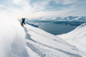 Ski alpinist skiing down the mountain Lyngen Alps, Norway 