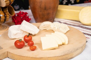 Closeup of a wooden tray with a variety of cheeses.