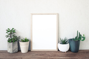 blank photo frame with cactus and succulents on table