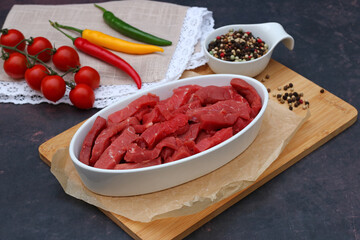In Streifen geschnittenes rohes Rindfleisch mit Tomaten, Peperoni und Gewürzen.