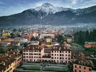 Drone view of Lake Como surrounded by a town and mountains in the evening in Italy