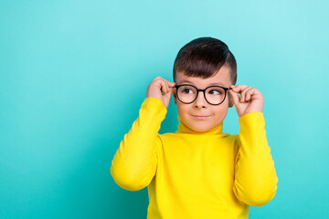 Photo of sweet adorable boy touch specs look empty space eyesight treatment for kids isolated cyan color background