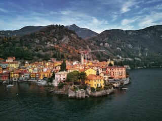 Fototapeta na wymiar Drone view of Lake Como surrounded by a town and mountains in the evening in Italy