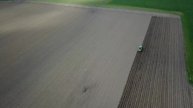 Un agriculteur s&egrave;me des pommes de  terre dans un champ avec son trateur