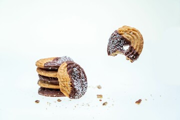 A closeup of half-eaten cookies with coconut and chocolate isolated on a white background