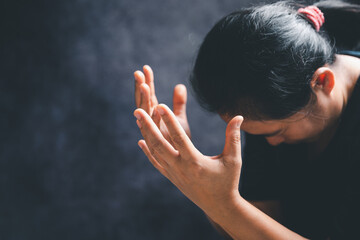 Hands folded in prayer on a Holy Bible in church concept for faith, spirituality and religion,...