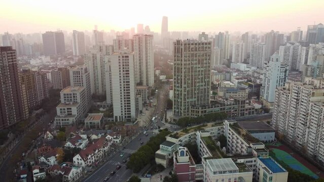 Drone view over a cityscape with high-rise buildings during a sunset