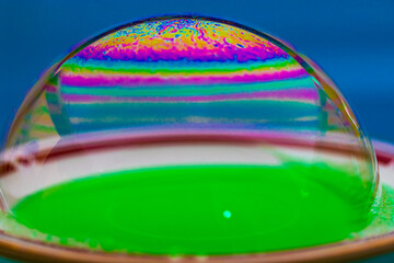 Vivid rainbow colours of a Macro soap bubbles creating psychedelic patterns under light dome...