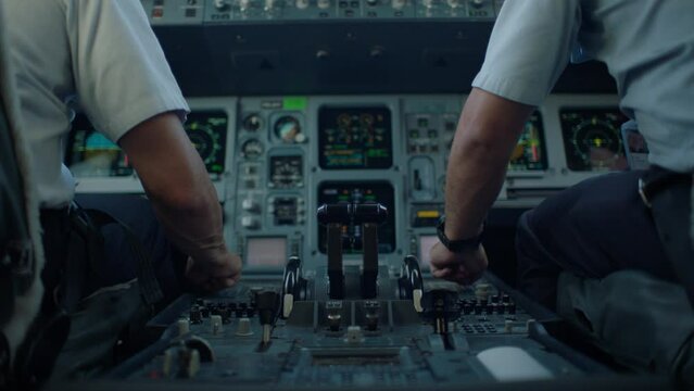 pilot and co-pilot adjusting plane controls