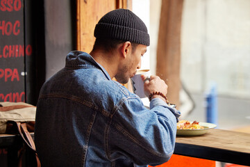 Take a minute to do something nice for yourself. a young man having lunch in a restaurant.