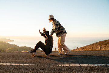 Happy man and woman with skateboard having fun on road
