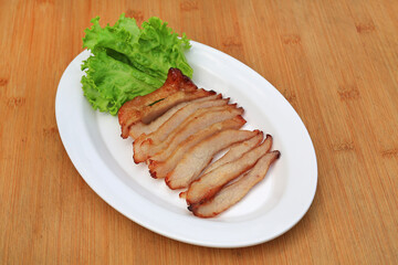 Grilled pork, Roasted pork neck in white plate on wood table. Thai food.