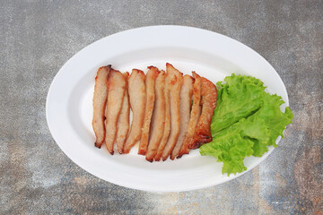 Grilled pork, Roasted pork neck in white plate on rust cement background - Thai style food. Top view.