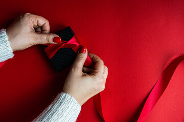 Woman holds the black box on red background