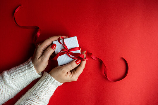 Woman holds the white box on red background