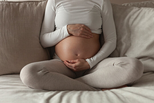 Pregnant woman holding her exposed belly