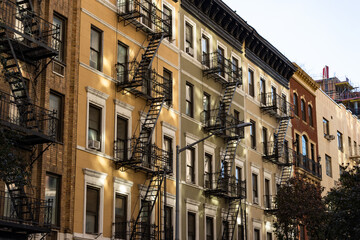 Fototapeta na wymiar Row of Colorful Old Apartment Buildings with Fire Escapes in Chelsea of New York City