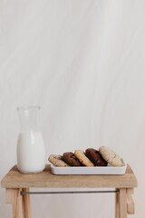 Vertical shot of freshly-baked chocolate cookies on a ceramic tray on the table