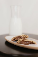 Vertical shot of freshly-baked chocolate cookies on a ceramic tray on the table